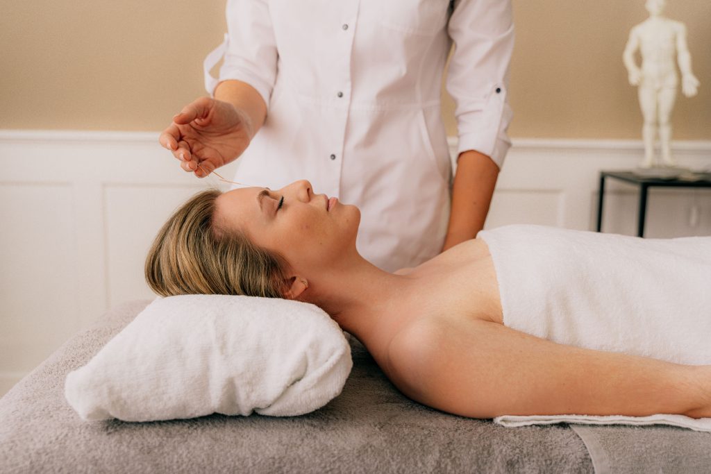 A client receiving acupuncture treatment at a wellness clinic.